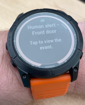 A garmin watch showing a notification: "Human alert - Front door. Tap to view the event"